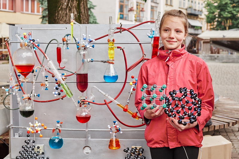 cute-school-age-girl-poses-near-model-with-chemical-process.jpg